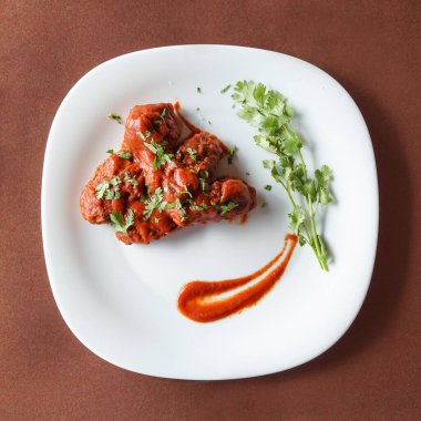 Barbekü kızarmış tavuk, ketçap ve ahşap bir masada kişniş.