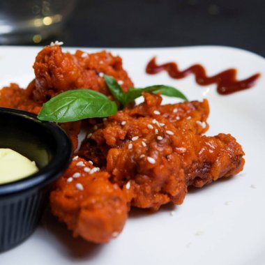 BBQ Chicken wings with mayo sauce and sesame beans topping in a plate