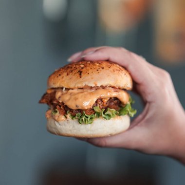 Sebzelerle dolu susamlı tavuklu zencefilli burger.