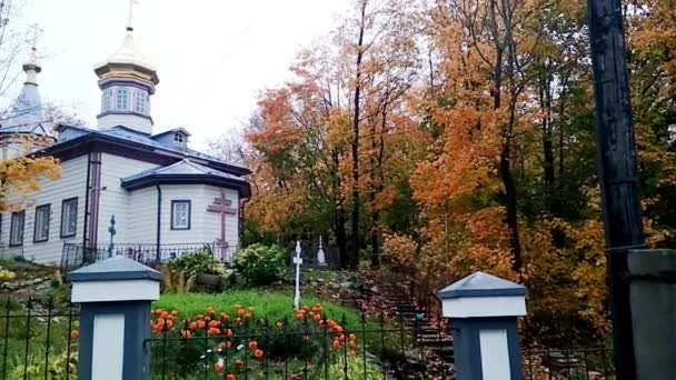 Ξύλινη Ορθόδοξη εκκλησία το φθινόπωρο στα βάθη του πάρκου. — Αρχείο Βίντεο
