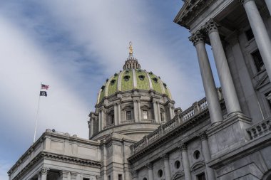 Harrisburg, Pennsylvania 11 Ocak 2026 Pennsylvania Eyalet Binası üzerinde kendine özgü yeşil kubbesiyle bayraklar dalgalanıyor..
