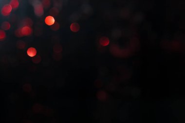 Bulanık ışık abstrakt arkaplan. Kırmızı ve turuncu ışıltılı ışıklar şenlikli arka plan. Parlak bokeh ile koyu arkaplan..