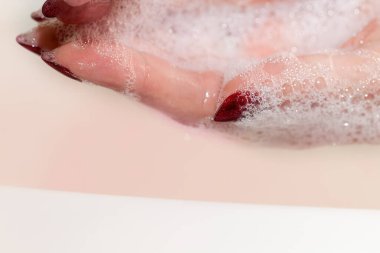 Seçici odaklanma. Güzel bir kadının eli ellerini lavaboda köpükle yıkar, cildini temizler. Sağlık ve güzellik kavramı. Sabunlu köpüklü kadın eli..
