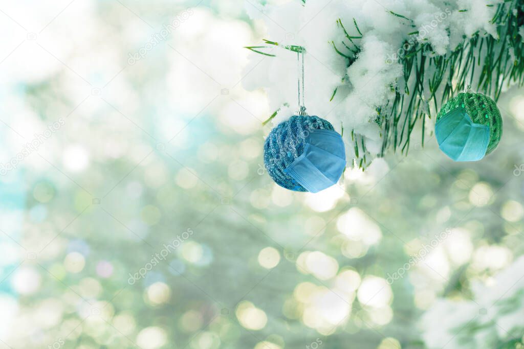 Two Christmas balls in medical masks. Social Distance Celebrating Christmas and New Year in Quarantine .Covid-19 Christmas Backgroud