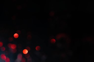 Bulanık ışık abstrakt arkaplan. Kırmızı ve turuncu ışıltılı ışıklar şenlikli arka plan. Parlak bokeh ile koyu arkaplan..