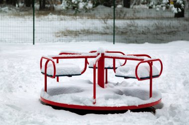 Şiddetli bir kar yağışı sonrası çocuk salıncağında kar. Atlıkarınca salla. Bir kar fırtınasında şehir hayatının şehir manzarası. Çocuk parkında kış. Parktaki oyun parkı karın altında