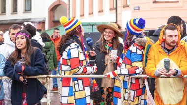 16 Şubat 2026. Mainz, Almanya. Rosenmontag Geçidi. RPR1 muhabiri renkli kostümlü karnaval katılımcılarıyla röportaj yapıyor.