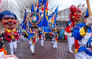 16 Şubat 2026. Mainz Rosenmontag Geçidi, Mainz, Almanya. MCV logosu olan Schwellkopp heykelciği ve neşeli katılımcı kalabalığı..