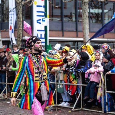 16 Şubat 2026. Rosenmontag Parade, Mainz, Almanya. Mainz Karnaval Geçidi 'nde Gökkuşağı Kostümlü Renkli Soytarı