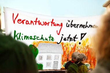 27 Şubat 2026, Mainz, Almanya. İklim aktivistleri protesto sırasında sorumluluk ve iklim koruması talep eden pankart taşıyorlar .