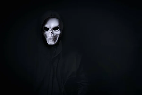 Mann im gruseligen Totenkopf-Cosplay in schwarz gekleidet zum Halloween-Fest auf schwarzem Hintergrund — Stockbild Mann Gruseligen Totenkopf Cosplay Schwarz Gekleidet Zum Halloween Fest Auf — Stockfoto