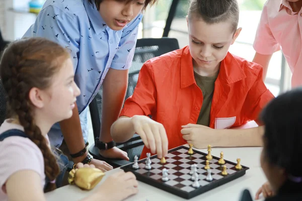 cute and smart kids playing chess in class (education concept