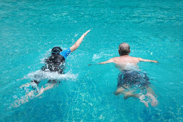 Vista Posteriore Coppia Pensionati Anziani Piscina Divertirsi Nuotare Insieme All — Foto Stock