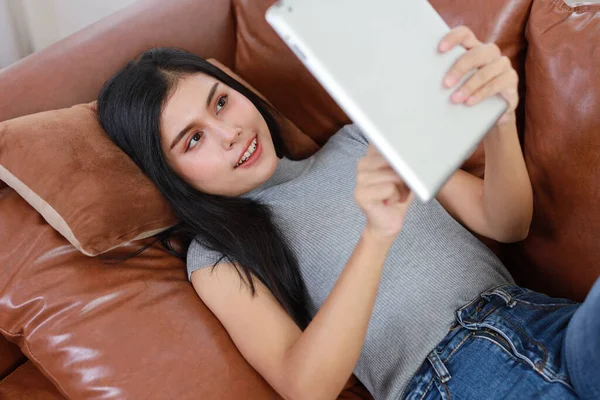 Joven Mujer Asiática Inteligente Activa Tumbada Sofá Sala Estar Usando —  Fotos de Stock