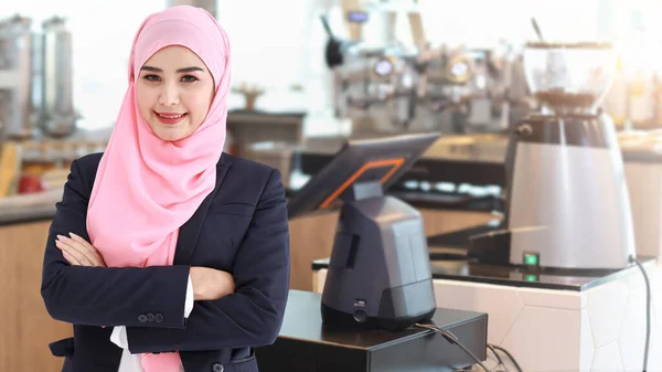 穿着西服的宗教亚裔穆斯林妇女站在那里 看着相机 并在咖啡店柜台前模糊的背景下保持自信 — 图库照片