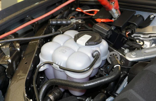 Expansion tank mounted on the engine of a modern car