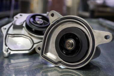 Modern bir arabanın soğutma sisteminin yakın çekim pompası. Arka planda bir soğutucu pompası daha var. Arkaplan bulanık.