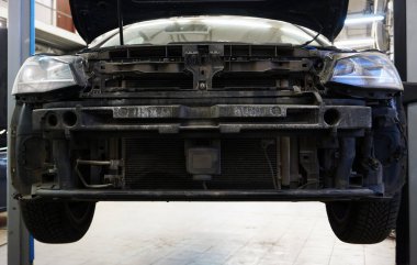 Araba servisindeki modern araba asansörde. Ön tampon araçtan çıkarıldı. Vücut onarımı.