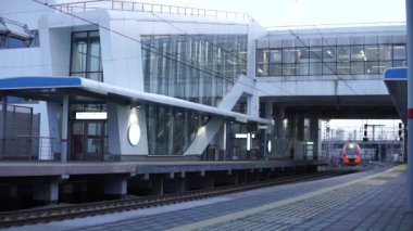 Moskova Rusya - 3 Nisan 2021: Modern yüksek hızlı güvenli şehir treni Swallow, Moskova Merkez Çemberi (MCC) istasyonlarından birinde. Tren köprünün altından geçiyor..