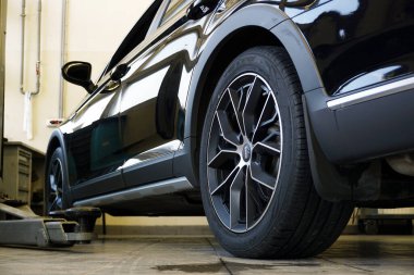 Moskova Rusya - 11 Mayıs 2021: Bir araba servisinde lüks siyah modern araba. Araba servisi, vücut tamiri ve yedek parça..