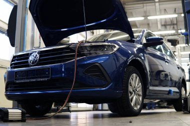 Moskova Rusya - 16 Mayıs 2021: Kaputu açık modern bir araba servisi. Teşhis ekipmanları makineye bağlandı.