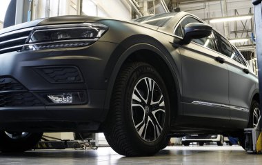 Moskova Rusya-20 Mayıs 2021: Lüks siyah SUV bir otomobil servis istasyonunda. Arka planda, bir araba servis istasyonunun içi, arka plan bulanık. Otomobil tamiri, yedek parça, vücut tamiri.