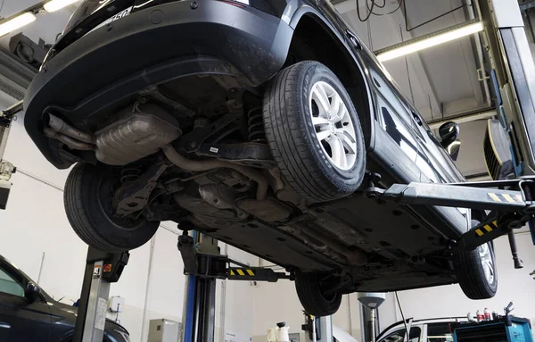 Moskova Rusya-20 Mayıs 2021: Bir benzin istasyonundaki modern bir araba, arabanın altından bir manzara, arka süspansiyon ve egzoz sisteminin ayrıntıları görünür. 