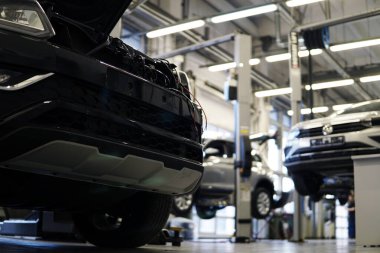 Moskova Rusya-25 Mayıs 2021: Modern araba servisi. Ön planda odaklanmış arabanın ön tarafı, arka planda ise bir araba servisi ve birkaç araba var. Arkaplan bulanık.