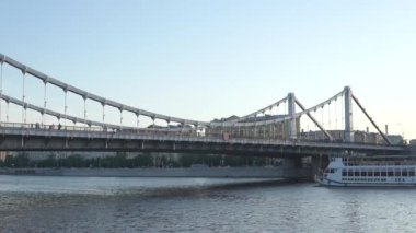 Moskova Rusya - 20 Haziran 2021: Küçük bir zevk motoru Moskova 'daki Kırım Köprüsü' nün altından geçiyor. Moskova 'da sıcak bir yaz akşamı..