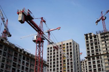 Moskova Rusya - Ağustos 2021: Modern bir konut kompleksinin inşası. İnşaat halindeki bir binanın arka planında yüksek katlı bir vinç var. Seçili odak.