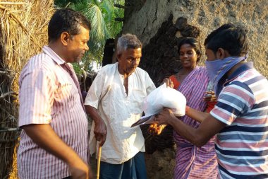 Barddhaman, Batı Bengal, Hindistan - 11 Mayıs 2020; bir grup genç adam Hindistan 'daki Corona salgını sırasında fakir köylülere yiyecek ve ihtiyaçlarını dağıtıyorlar..