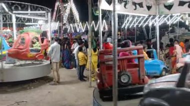 Hindistan, Kolkata 'da bir akşam panayırı var. Çocuklar ve yetişkinler lunapark treninin, dönen trenin ve parlak elektrik ışığının keyfini çıkarıyorlar..
