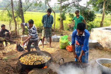 Katwa, Batı Bengal, Hindistan - 8 Kasım 2018: Batı Bengal 'deki köylüler büyük bir piknik için geleneksel kil ocakları ve büyük demir kazanlarla büyük gruplara yemek hazırlıyorlar..