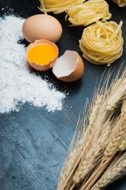 Yiyecek yumurta, un, makarna ve arpa siyah ahşap zemin üzerine temiz