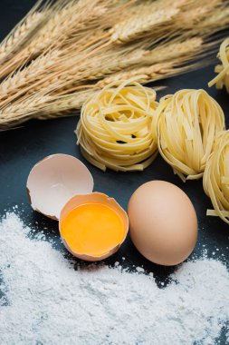 Yiyecek yumurta, un, makarna ve arpa siyah ahşap zemin üzerine temiz