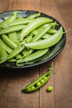 Arka plan üzerinde taze bezelye woodden