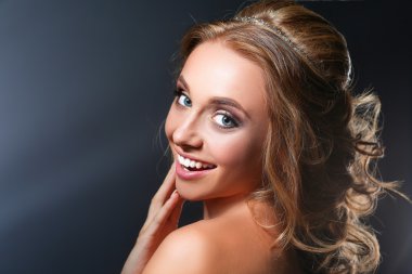 Koyu arka plan üzerinde kıvırcık uzun saçlı güzel kadın