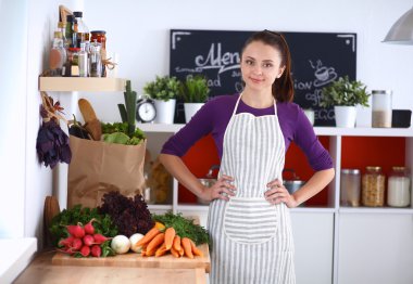 Onun mutfak masa alışveriş torbaları ile yakın duran genç kadın