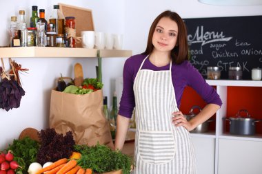 Onun mutfak masa alışveriş torbaları ile yakın duran genç kadın