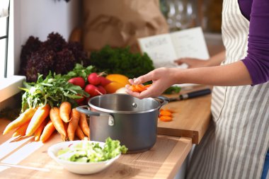 Mutfakta sebze doğrayan genç bir kadın.