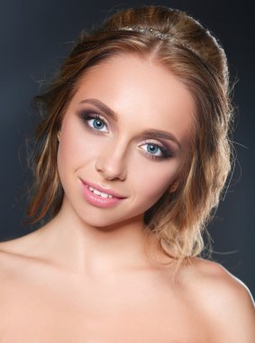 Koyu arka plan üzerinde kıvırcık uzun saçlı güzel kadın