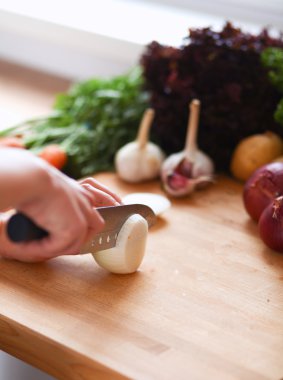 Mutfaktaki masanın üstünde sebzeler var.