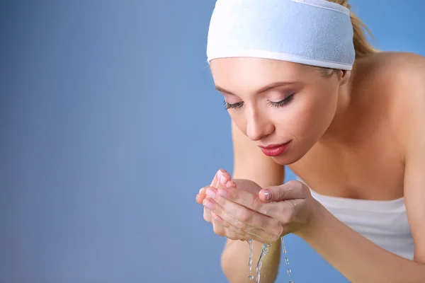 Mujer joven lavándose la cara con agua clara —  Fotos de Stock