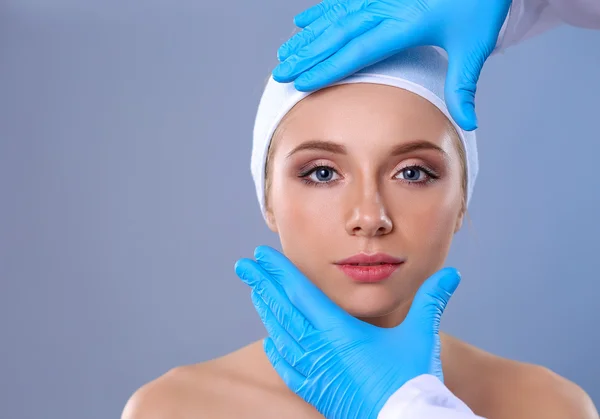Een chirurgen handen aanraken van een vrouwelijk gezicht — Stockfoto