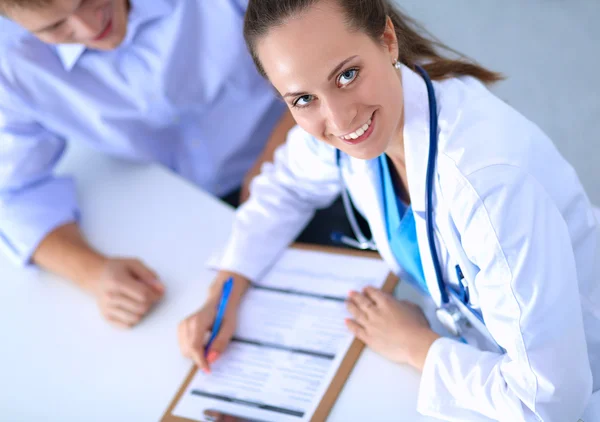 Doctor woman sitting with  male patient at the desk — Stock Photo, Image