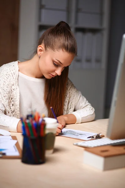 Jonge vrouw werkt in het kantoor, zit aan het bureau — Stockfoto