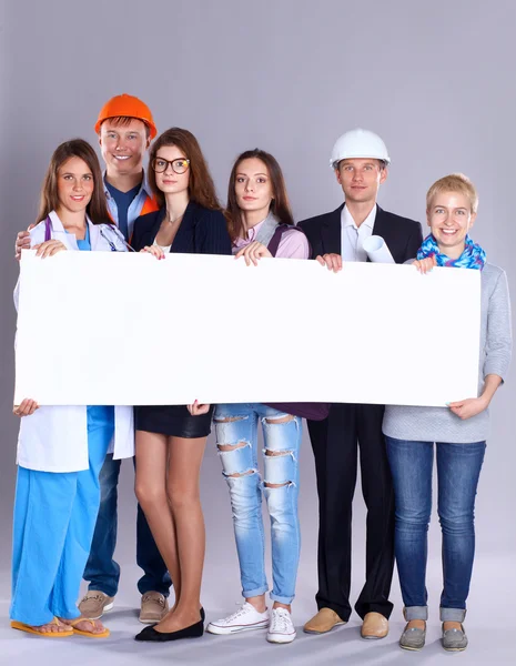 Retrato de personas sonrientes con varias ocupaciones sosteniendo cartelera en blanco — Foto de Stock