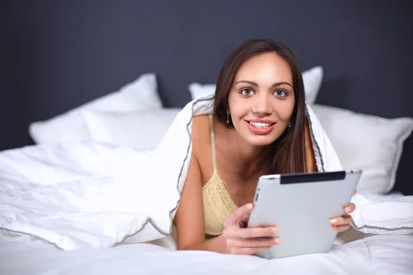 Vrouwen gebruiken een tablet pc op het bed — Stockfoto