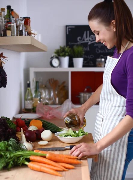 Young woman cutting vegetables in the kitchen — Stock Photo, Image