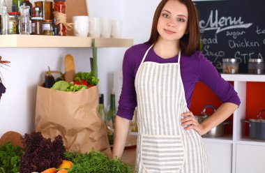 Onun mutfak masa alışveriş torbaları ile yakın duran genç kadın